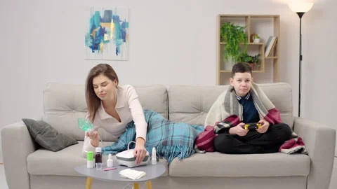 A young woman is lying on the couch using an inhalation nebulizer at home Stock-Footage 262995059