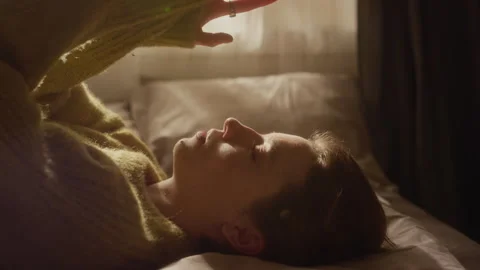 Young Woman Lying down on Bed while Coping with Anxious Thoughts in Bedroom Stock Footage 330602489