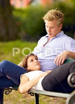 Young woman lying on her boyfriend's lap Stock Photos