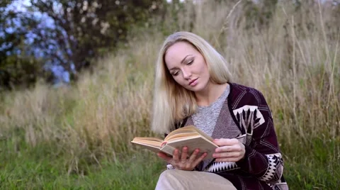 Young woman lying. reading book and wathing at camera 動画素材 55390553