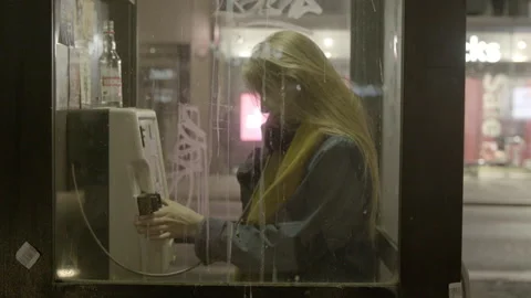 Young Woman Making Call Inside Public Phone Booth at Night Stock Footage 344620284