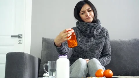 Young woman making a choice between food supplements and citrus fruit. Vitamin C Stock Footage 100719258