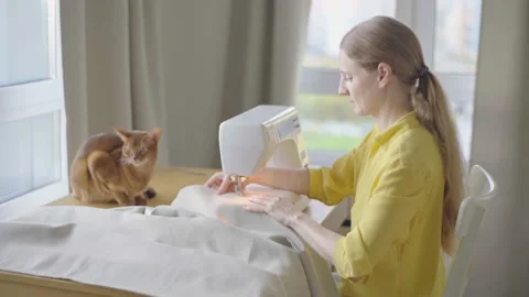 Young woman making clothes using sewing machine Stock Footage 229640604