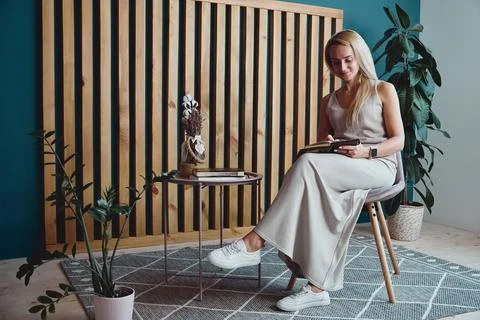 Young woman making notes in notebook sitting at workplace at home, remote work Stock Photos