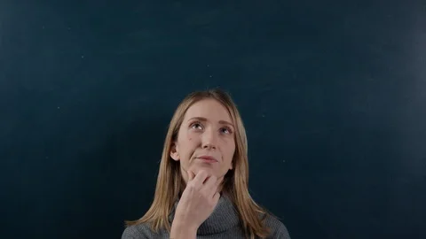 Young woman making various facial expressions in front of blackboard Stock Footage