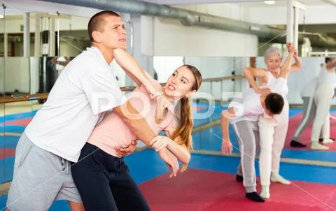 Young woman with male partner practicing basic elbow kick to chin ...