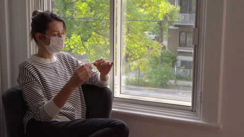 Young Woman measures temperature on self isolation at home on quarantine.  Stock Footage 139374331