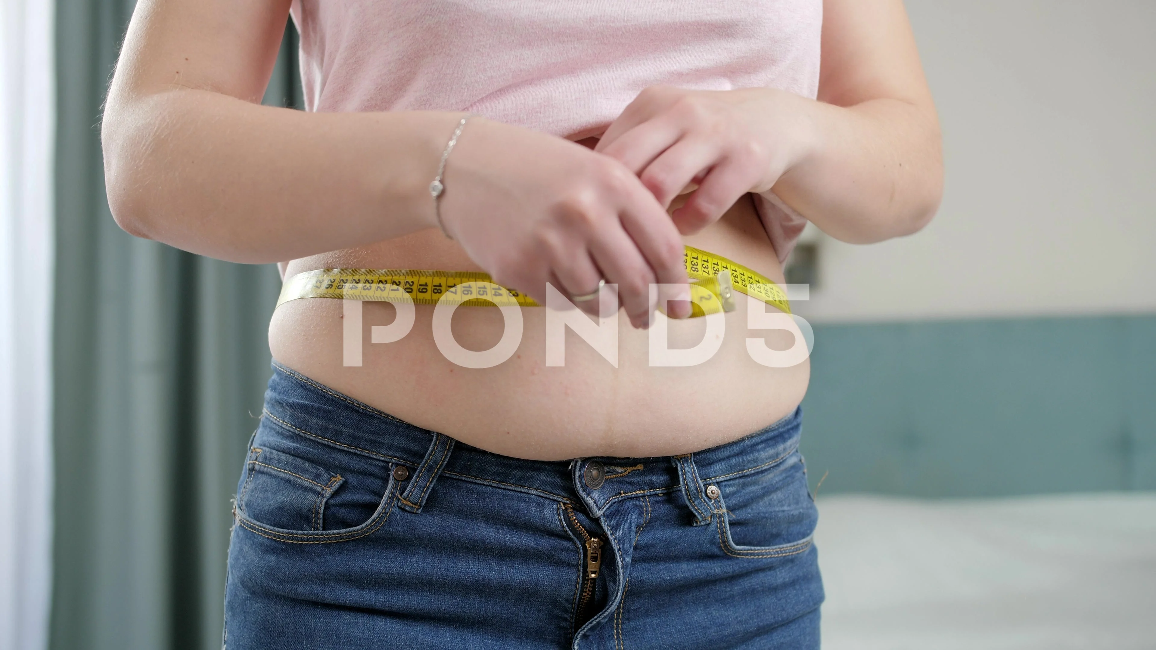 a guy with a big belly and a slim girl measuring waist measuring tape on a  white background Stock Photo, Waist Measuring Tape 