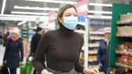 A Young Woman In A Medical Mask Walks With A Grocery Cart In A Supermarket Stock Footage