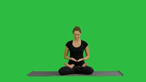 Young woman meditates while practicing yoga on a Green Screen, Chroma Key 스톡 동영상 74853643