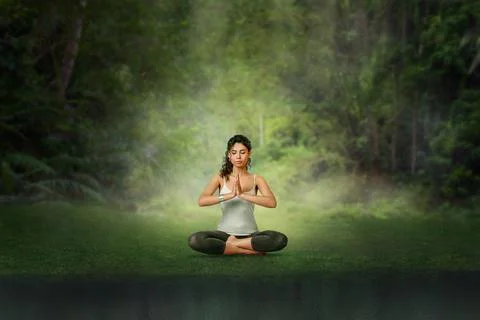 Young woman meditation in Lotus position at tropical forest. Woman doing yoga Stock Photos