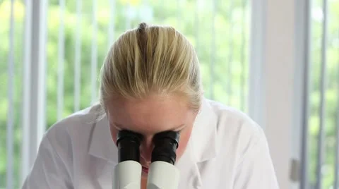Young woman with microscope Vidéo 8577022