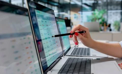 Young Woman Multitasks Using Multiple Screens Analyzing Supplier Data Efficie 写真素材