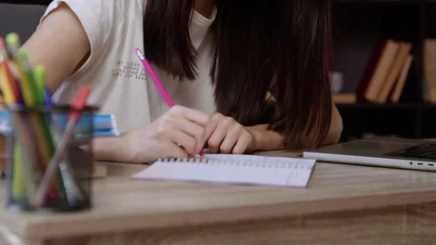 Young woman notes down academic materials in college library Stock Footage 300381055