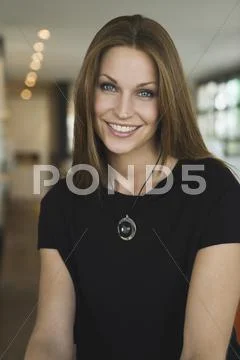 Young woman in office, smiling, portrait Stock Photos