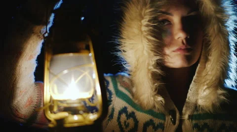 Young woman with an oil lamp in the dark. Fearfully looking around Stock Footage