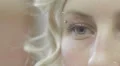 A young woman opens and closes her blue eye - macro HD Footage