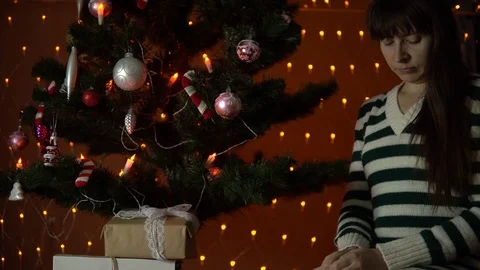 Young woman opens a gift box under the Christmas tree. Stock Footage 81994221