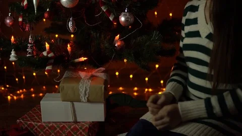 Young woman opens a gift box under the Christmas tree. Stock Footage 81995616