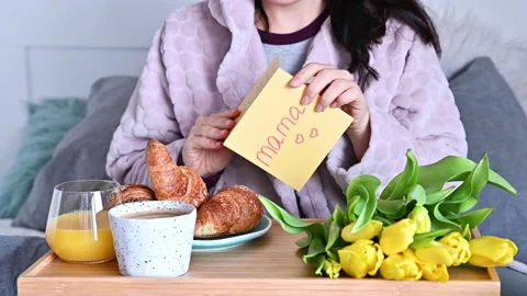 Young woman opens a postcard with a stack of mom in English. Stock Footage 146247950