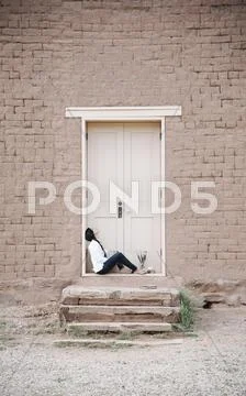 Young woman outside the front door of a building. Stock Photos