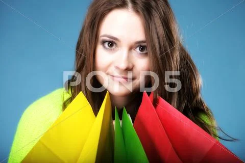 Young woman with paper multi coloured shopping bag Stock Photos