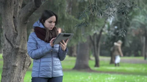 Young woman in a park with tablet Stock Footage 63392702
