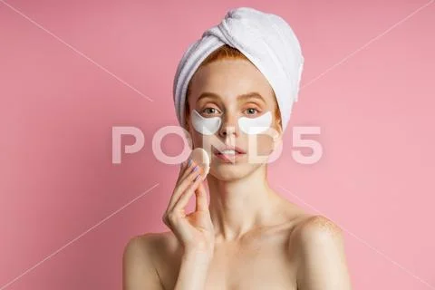 Young woman with patches under eyes isolated on pink background Stock Photos