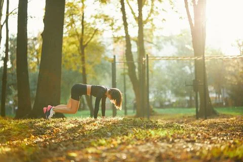 Young woman performing in pilates at city park Stock Photos