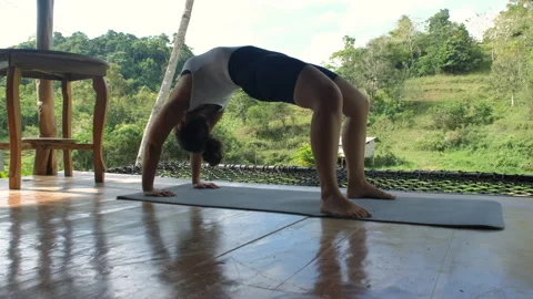 Young woman performs bridge yoga pose in tropics Stock Footage 309270341