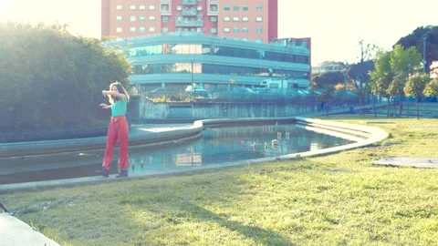 Young woman performs synchronized dance steps on the edge of a fountain Vidéo 154134694