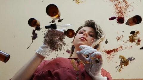 Young woman perfumer preparing herbs and flowers for make a perfume. Vidéo 107497628