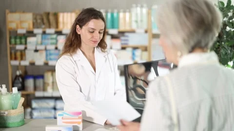 Young woman pharmacist uses a computer to check the availability of medicines Vídeos de archivo 330040184