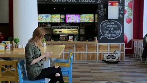 Young woman with phone in cafe Stock Footage