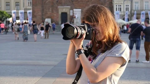 Young woman photographer take picture with professional photo camera in public Stock Footage