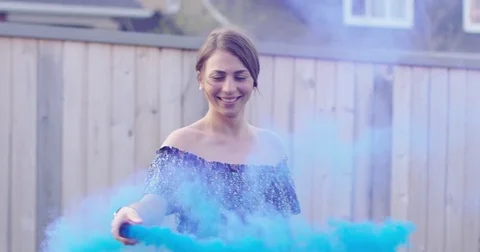 Young woman playing with blue smoke bomb - slow motion Stock Footage