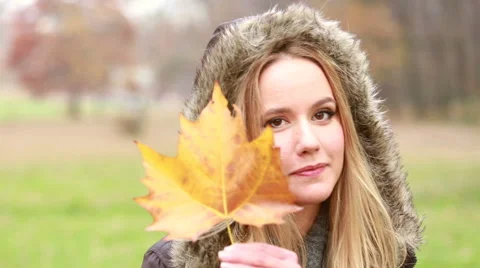 Young woman playing with leaf and smiling Stock Footage 59554418