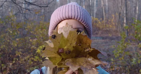 Young woman playing with maple leaves Stock Footage