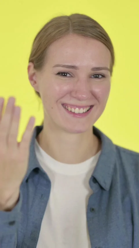 Young Woman Pointing at Camera, Inviting on Yellow Background , Vertical Video Stock Footage 340041216