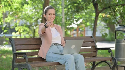 Young Woman Pointing at Camera while Using Laptop Outdoor Video stock 282654145