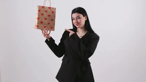 Young Woman Pointing at Heart Patterned Shopping Bag Isolated on White Back.. Stock Footage 346113060