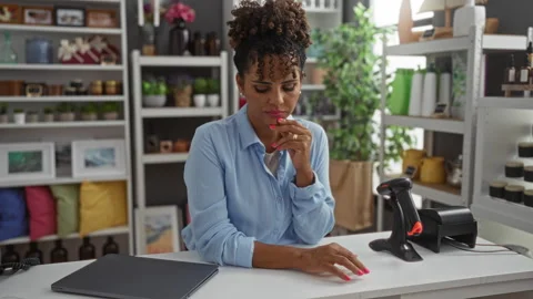 Young woman pondering while standing at the counter of a home decor store f.. Stock Footage 281799297