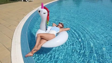 Young woman on pool float in pool in hotel. Summer holidays, enjoying summer Stock Footage 268448880