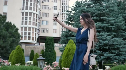 Young woman posing and taking pictures herself in selfie camera phone in summer Stock Footage 137125138