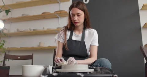Young woman in pottery studio using pottery wheel, handmade ceramics, creative Stock Footage 155357848