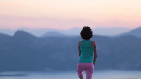 Young woman practice yoga on mountain top in sunrise Stock Footage