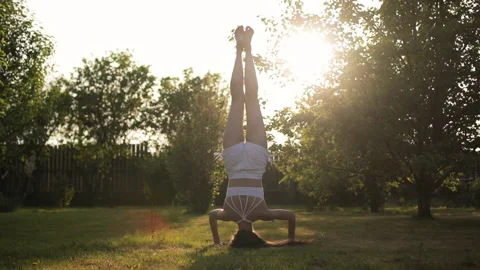 Young woman practicing yoga headstand in nature Stock Footage 130897953