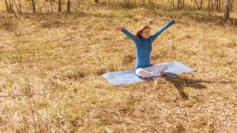 Young woman practicing yoga in a spring forest. 動画素材 80597520