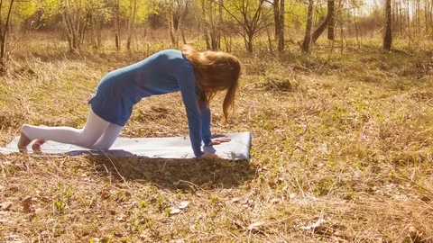 Young woman practicing yoga in a spring forest. Video stock 80606173