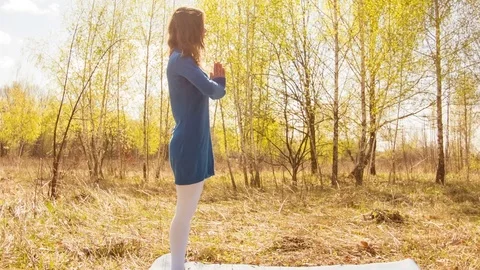 Young woman practicing yoga in a spring forest. Video stock 80615107